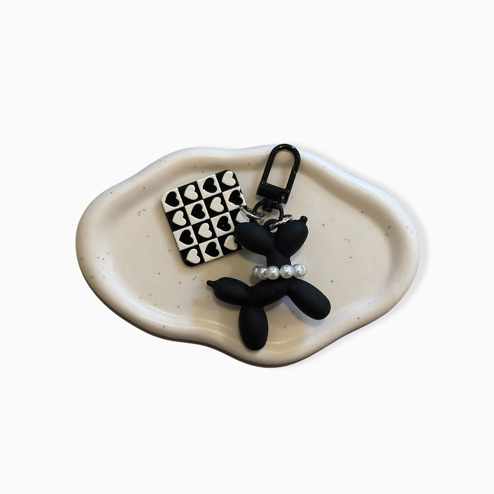 Unique balloon dog charm in black & white checkered design – stylish bag accessory